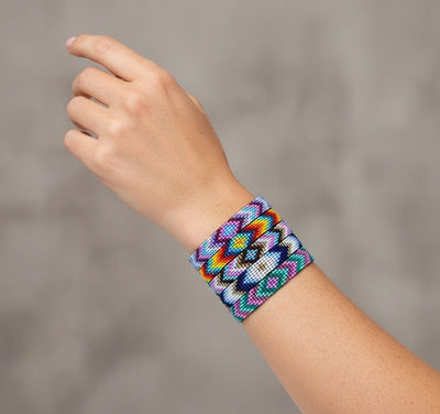 Colorful beaded bracelet on a wrist against a neutral background