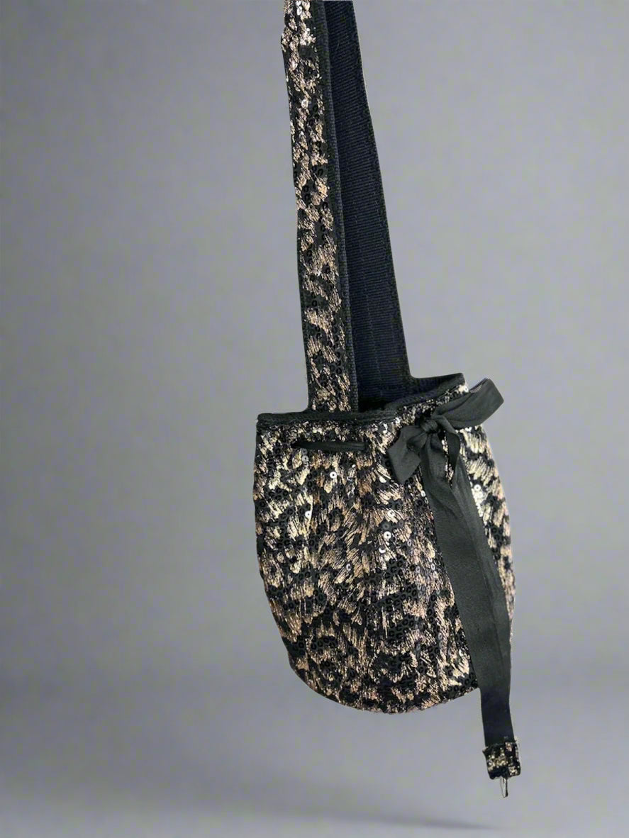 Leopard print bag with a black strap on a gray background