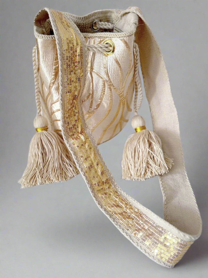 Beige handbag with decorative tassels on a white background